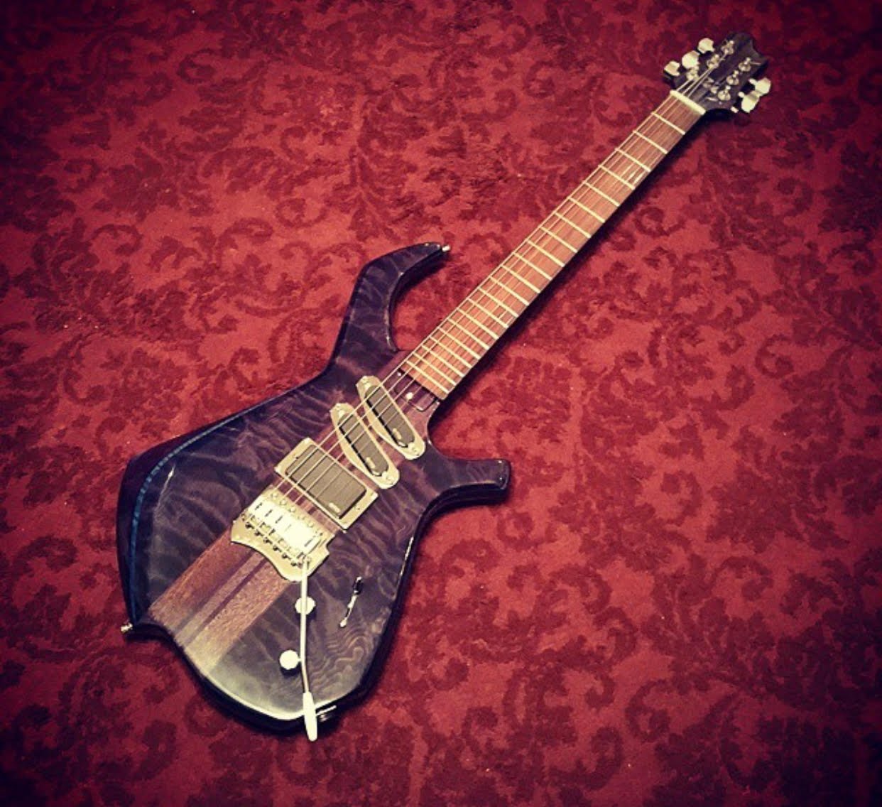Blue quilt-top electric guitar on red damask