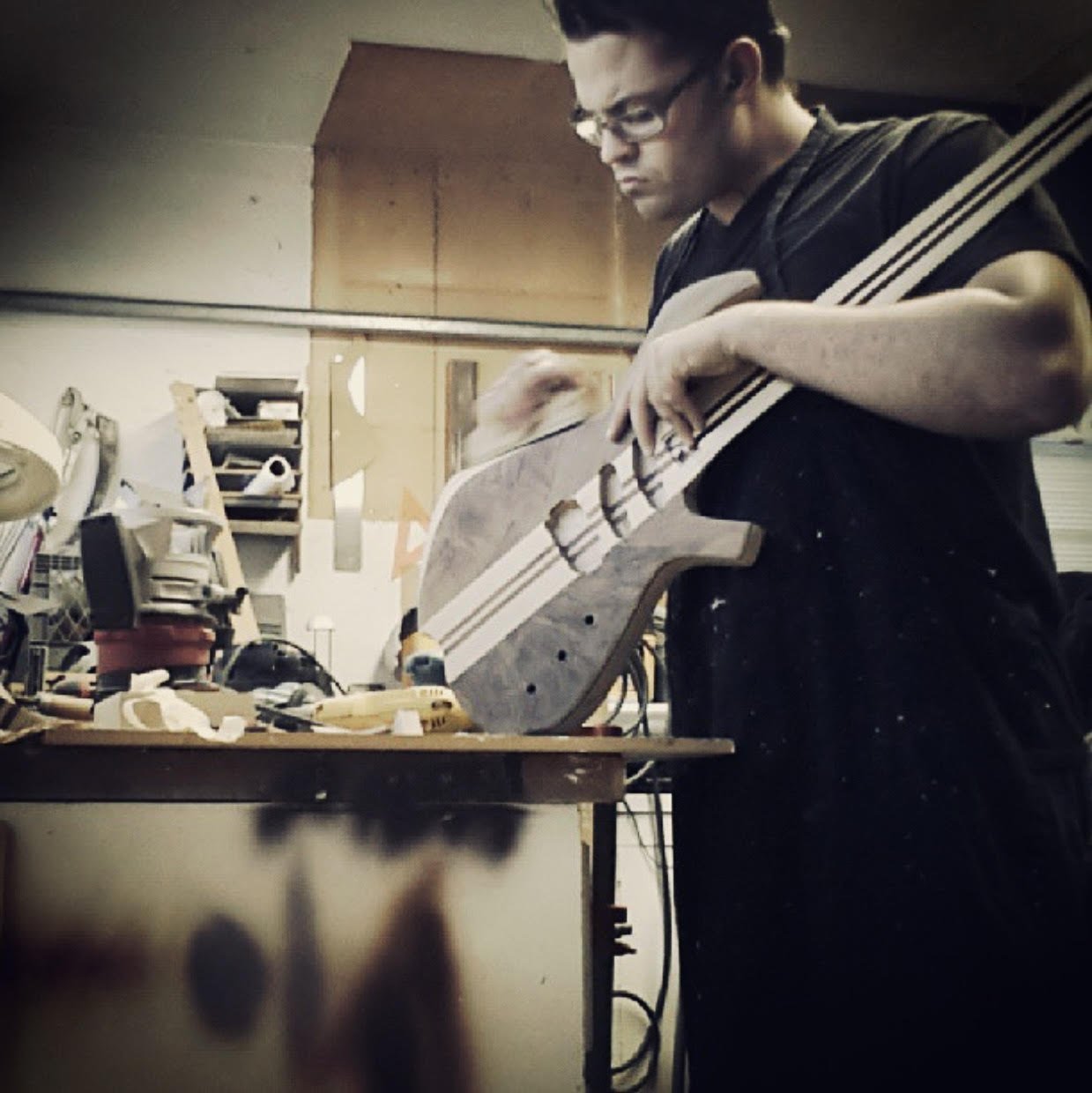 Michael A. Thomas shaping a bass body at the bench